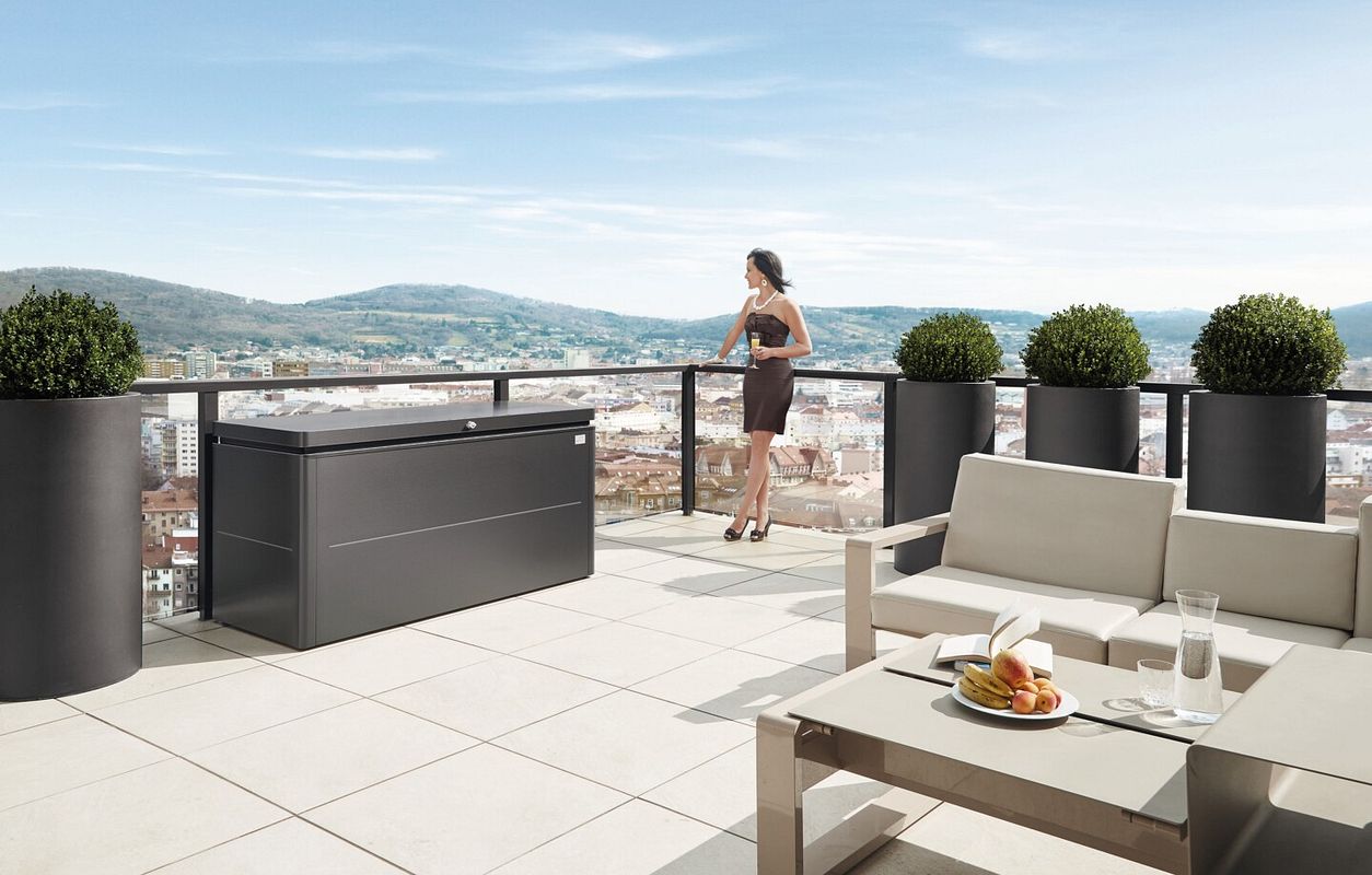 Frau auf Terrasse mit Gartengerätebox