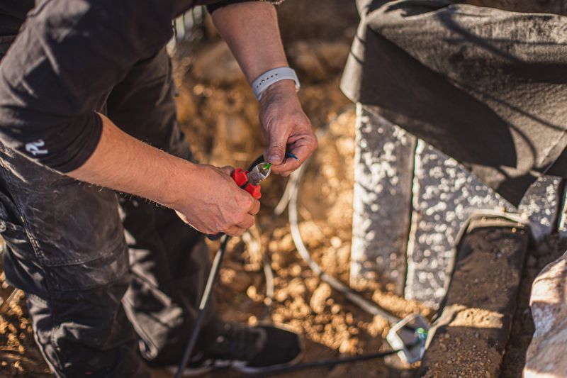 Unser Experte schließt kürzt das Kabel der Gartenbeleuchtung auf die richtige Länge